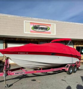 boat with red canvas in front of lakeside marine store